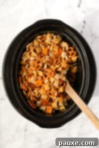 Effortless Slow Cooker Party Mix 18 Stirring cooled Chex Mix in a slow cooker.