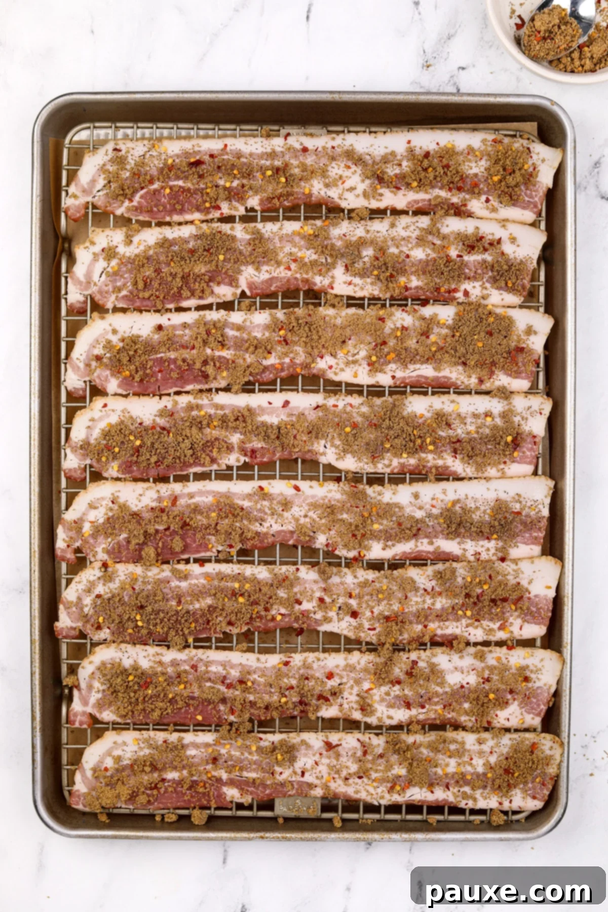 Decadent Glazed Bacon 7 Bacon slices on a baking sheet, generously sprinkled with the brown sugar and spice mixture.