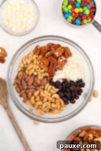 Trailblazer's Blend 13 A bowl filled with different sections of nuts, coconut, and dried fruit.