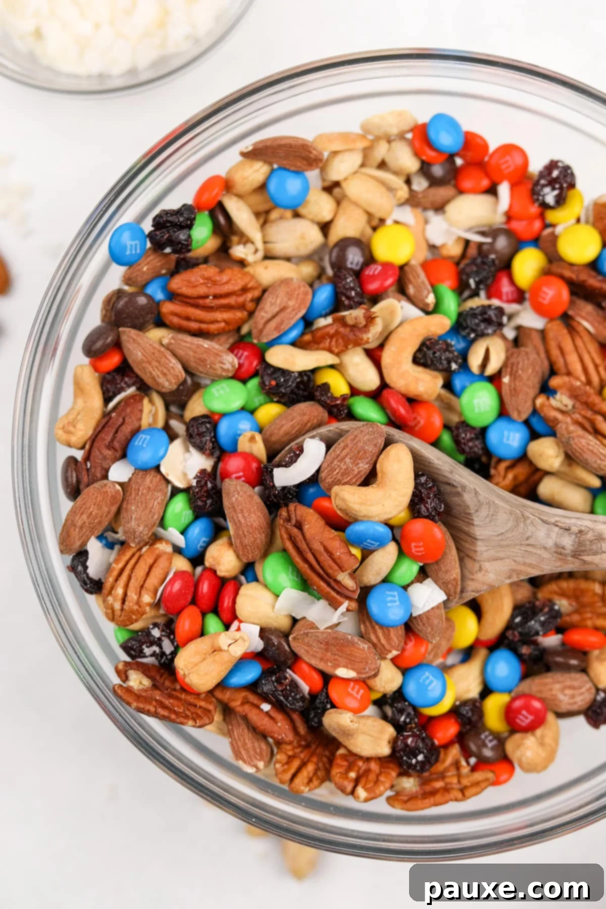 Trailblazer's Blend 10 A large bowl of trail mix being scooped with a wooden spoon, ready for serving.