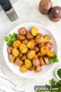 A white plate filled with roasted red baby potatoes.