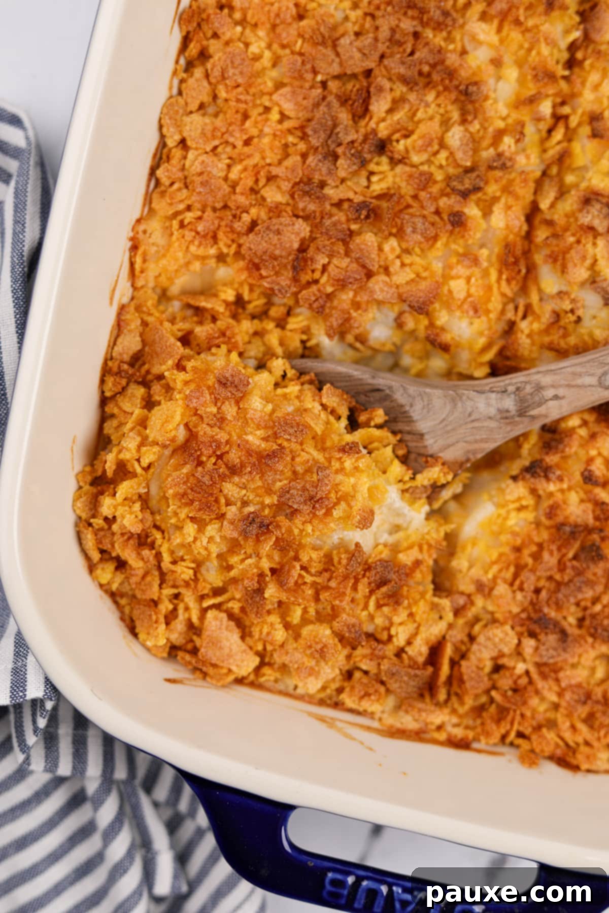 Gluten-Free Cheesy Hash Brown Casserole 2 A golden-brown baking dish of gluten-free hash brown casserole, perfectly baked with a crispy corn flake topping, ready to be served.