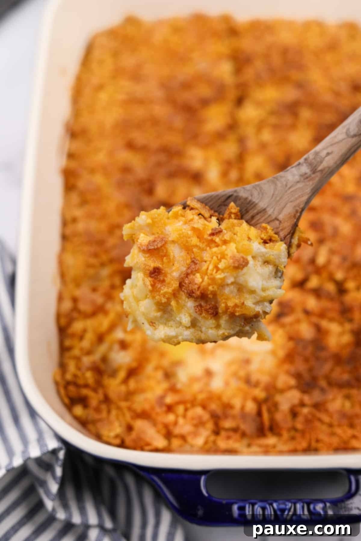 Gluten-Free Cheesy Hash Brown Casserole 15 A scoop of delicious, creamy gluten-free hash brown casserole, rich with cheese and a golden corn flake topping, taken directly from the baking dish.