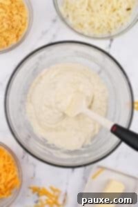 Gluten-Free Cheesy Hash Brown Casserole 20 A large bowl with a creamy sauce in it.