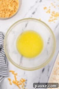 Gluten-Free Cheesy Hash Brown Casserole 24 A bowl of melted butter.