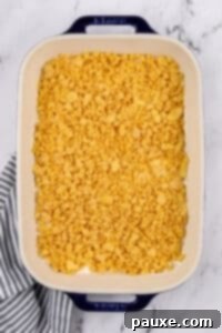 Gluten-Free Cheesy Hash Brown Casserole 26 A baking dish filled with a casserole and topped with a buttery corn flake layer.