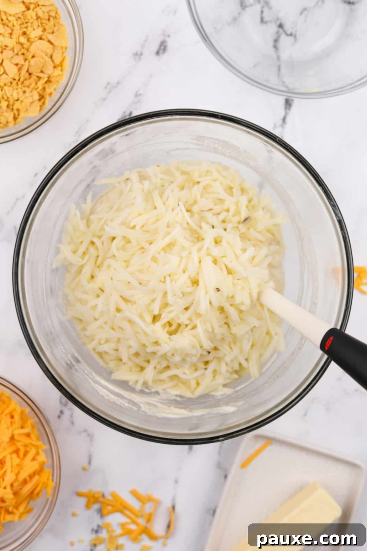 Gluten-Free Cheesy Hash Brown Casserole 6 A large mixing bowl filled with thawed, shredded hash browns, lightly fluffed and ready to be coated in the creamy sauce for the gluten-free funeral potato casserole.