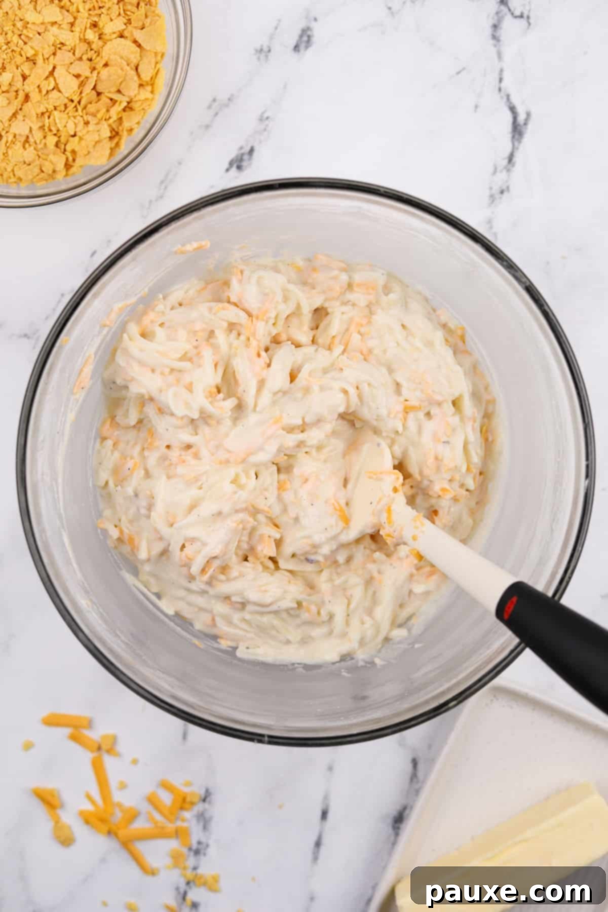 Gluten-Free Cheesy Hash Brown Casserole 8 A large mixing bowl filled with the fully combined hash brown casserole mixture: creamy, cheesy potatoes perfectly blended and ready for the baking dish.