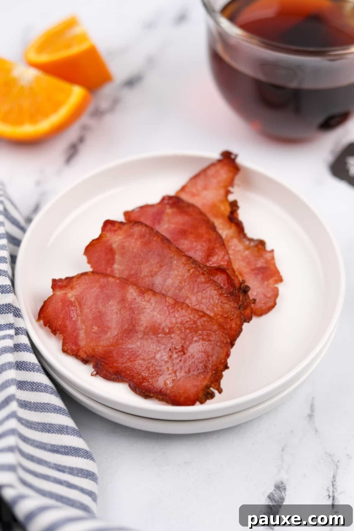 Easy Air Fryer Canadian Bacon 2 A plate featuring four slices of perfectly cooked, golden-brown Canadian bacon.