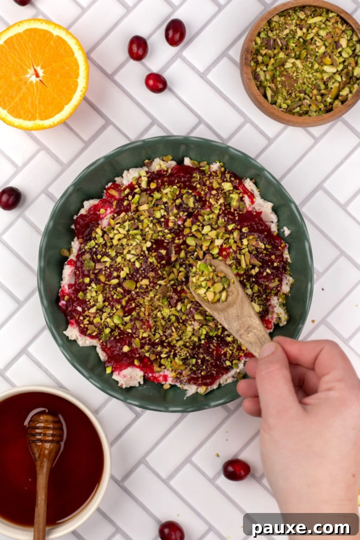 Sprinkling chopped pistachios over the cranberry sauce