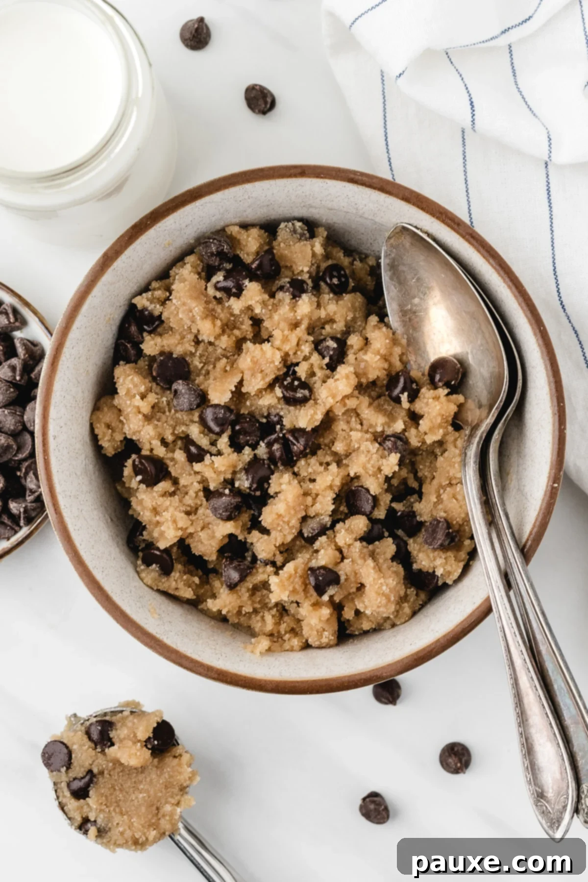 Safe-to-Eat Cookie Dough 6 A bowl of chocolate chip cookie dough with a spoon on the side, and a glass of milk just out of view.
