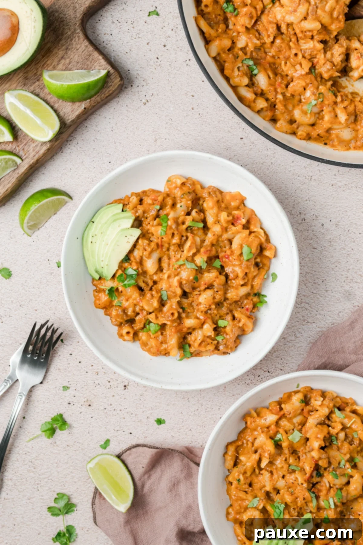 Taco Mac 'n' Cheese Explosion 5 A single serving of Taco Mac and Cheese in a bowl, garnished with fresh avocado and cilantro for a visually appealing and flavorful dish.
