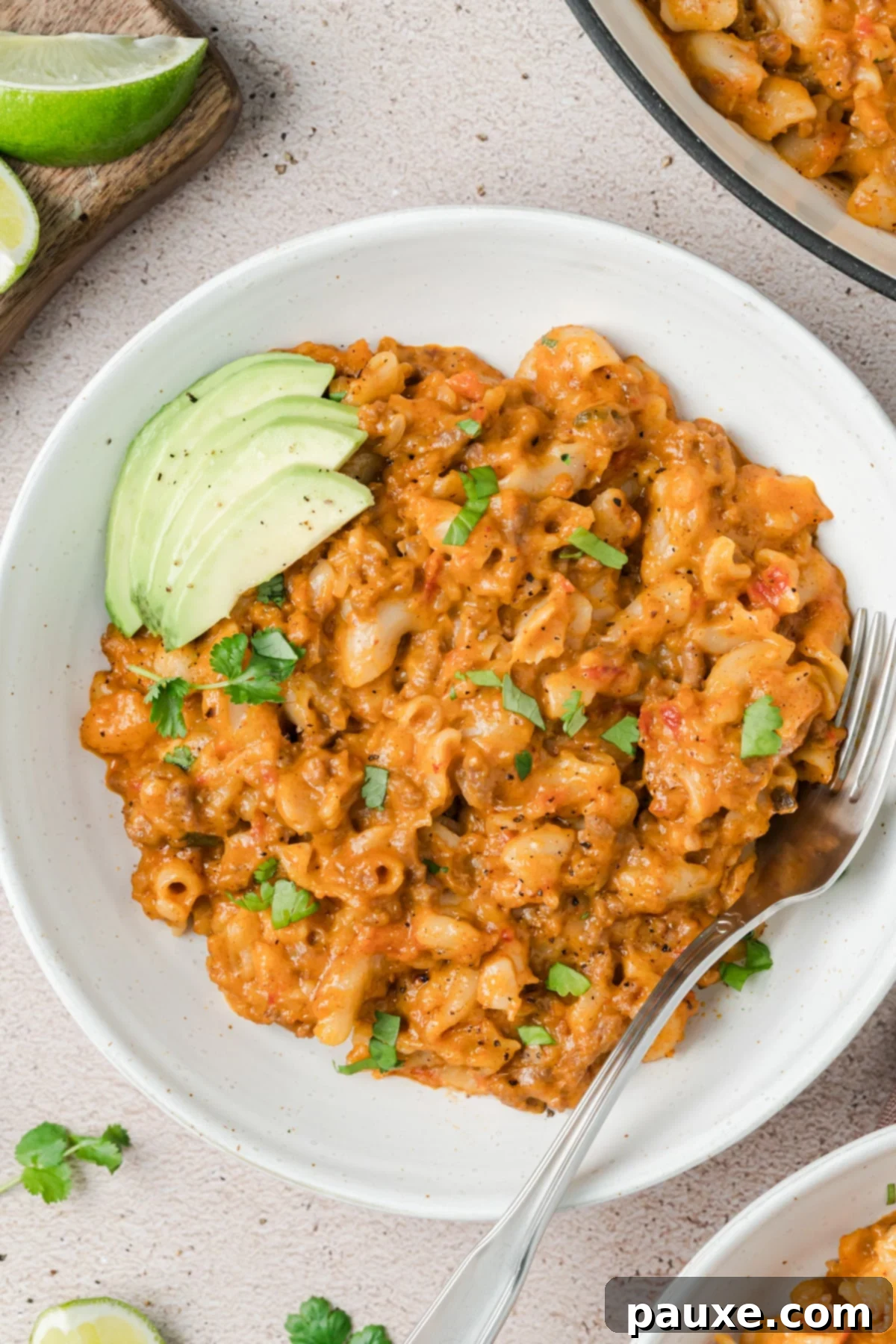 Taco Mac 'n' Cheese Explosion 6 Another close-up shot of Taco Mac and Cheese, this time showcasing a variety of toppings like avocado and cilantro, highlighting the dish's versatility.
