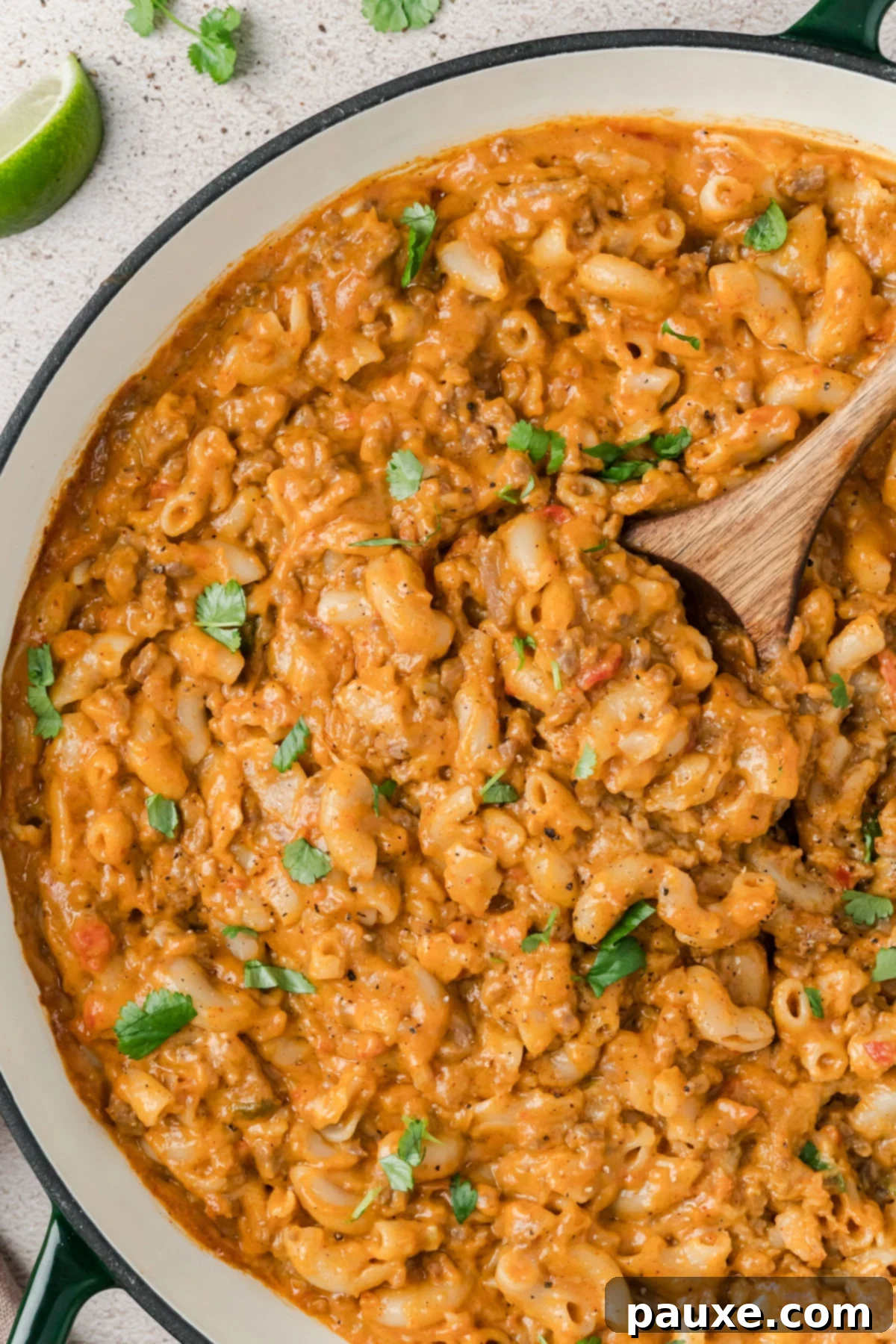 Taco Mac 'n' Cheese Explosion 7 A skillet filled with Taco Mac and Cheese, garnished generously with fresh cilantro, ready to be served and enjoyed.