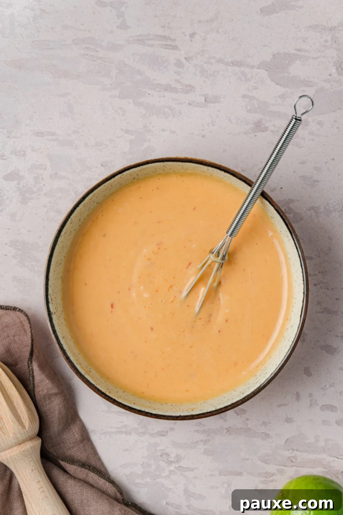 Bang Bang Chicken Salad: A Flavor Explosion 4 A bowl of homemade bang bang dressing with a whisk.