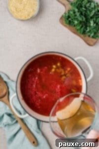 Vegetarian Orzo Delight 10 Pouring broth and tomatoes into a Dutch oven
