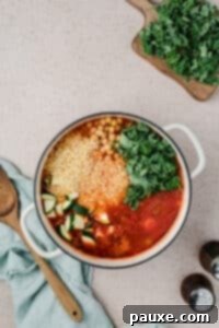 Vegetarian Orzo Delight 11 Adding orzo, kale, and vegetables to a Dutch oven filled with soup