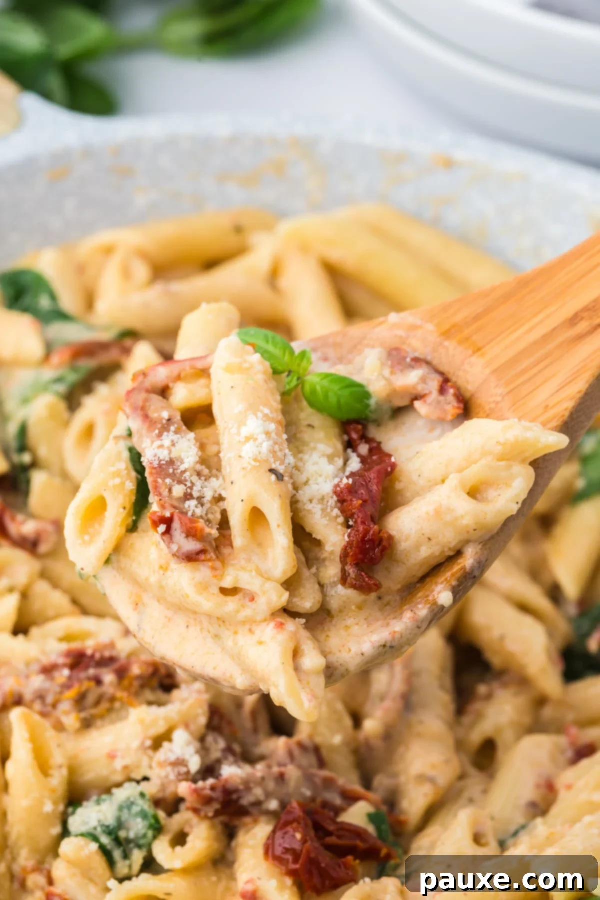 Delicious Creamy Tomato Pasta 2 Creamy sun-dried tomato pasta being served from a skillet