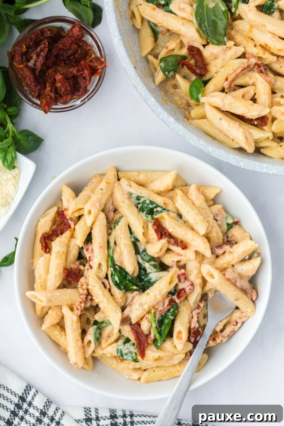 Delicious Creamy Tomato Pasta 7 A close-up of creamy penne pasta with sun-dried tomatoes and spinach